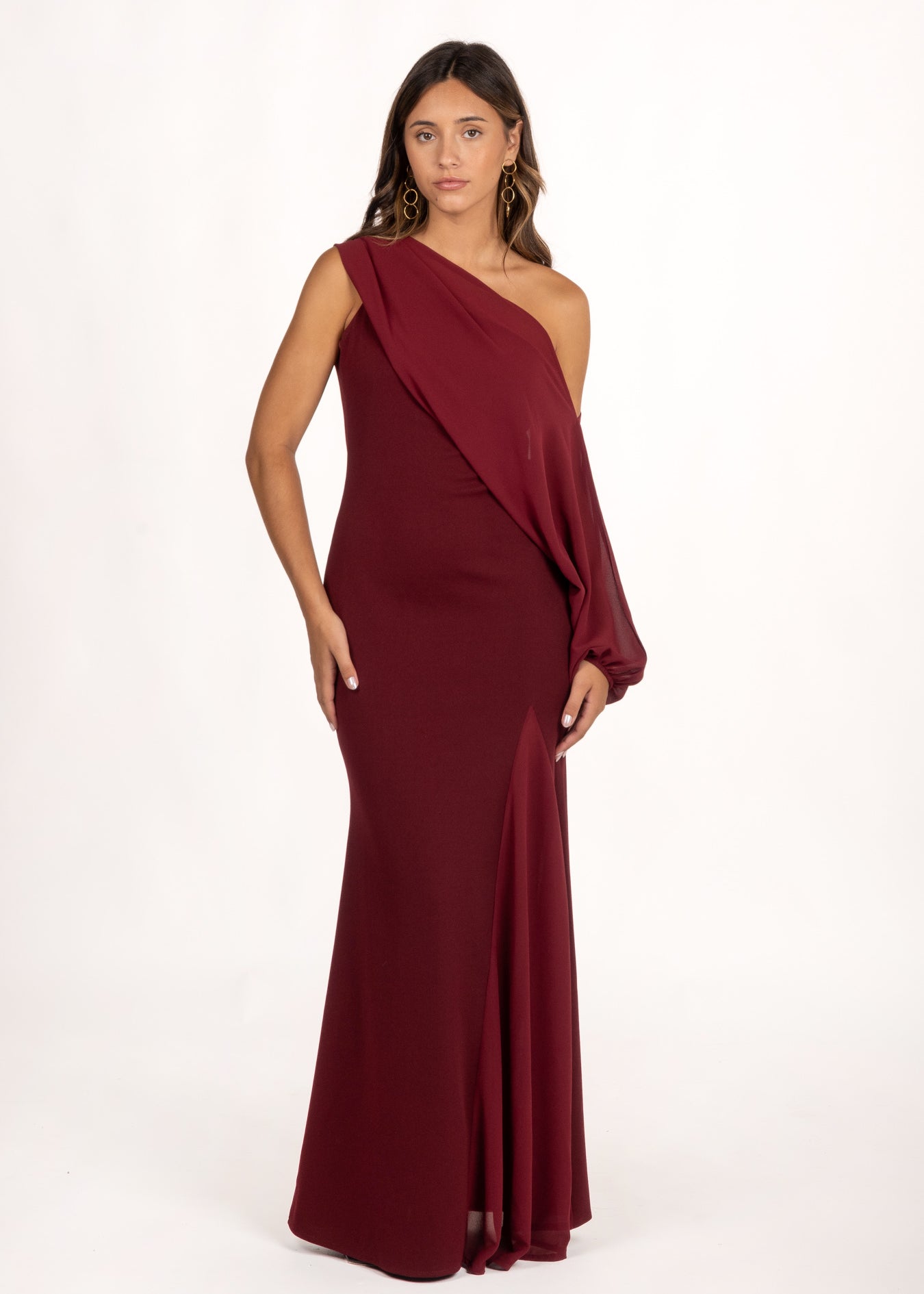 Vestido asimétrico color granate con manga extraíble, perfecto para un look de invitada de otoño. Su diseño versátil ofrece dos estilos: uno sofisticado con manga fluida, y otro más minimalista y elegante sin ella. La falda con godete aporta movimiento, ideal para bodas, galas y eventos especiales.