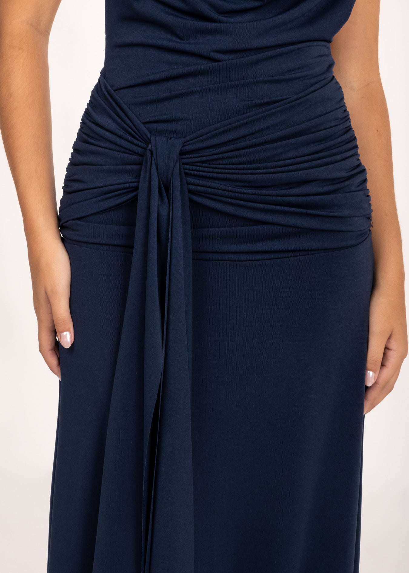 Vestido Kala azul noche, ideal como vestido de invitada de otoño o vestido de graduación. Su escote en cascada y fruncido realzan la figura, mientras la lazada lateral y la espalda descubierta aportan un toque elegante y sofisticado para ocasiones especiales.