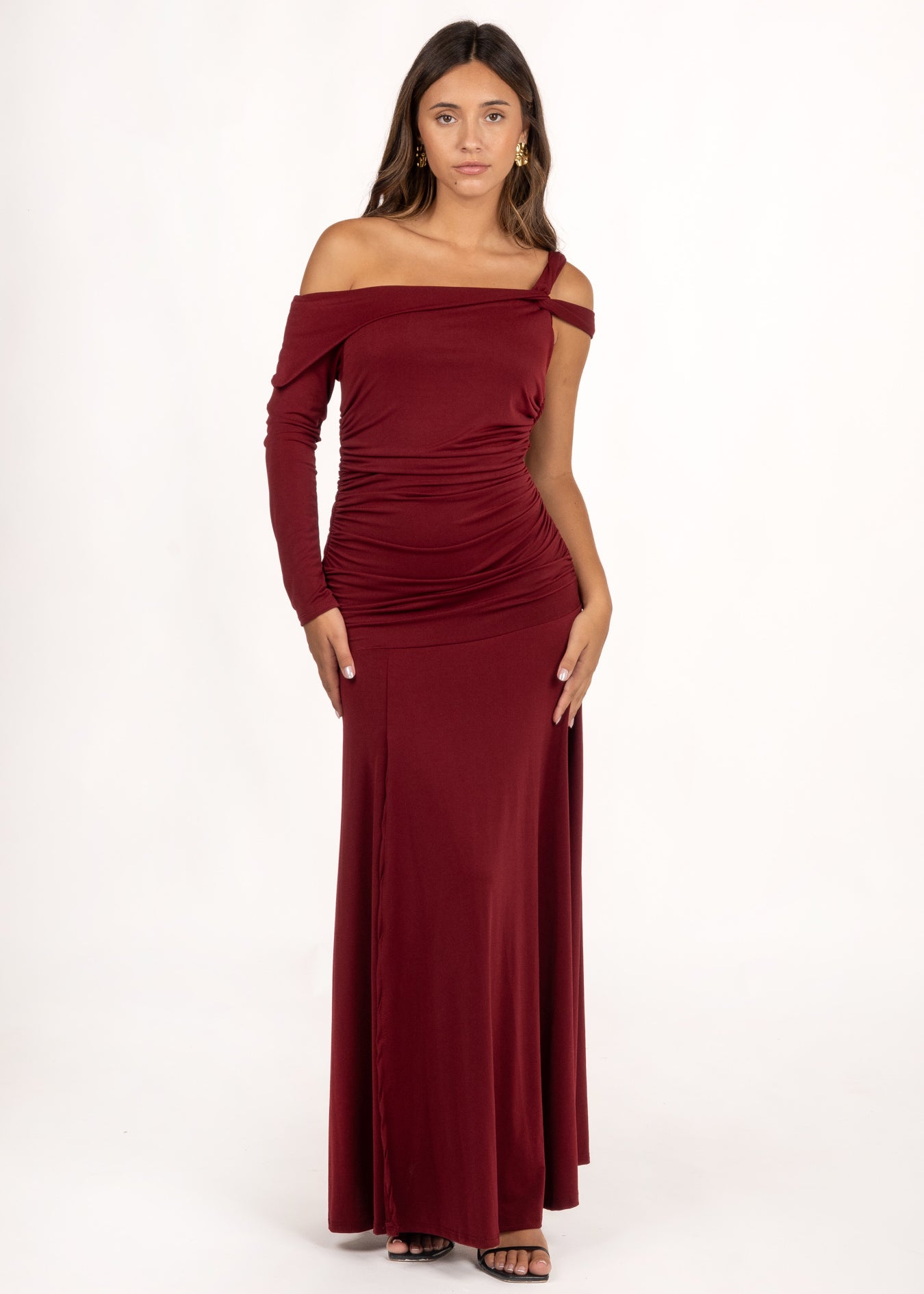 El Vestido Ovara Granate es perfecto para eventos especiales. Destaca por su escote asimétrico con manga larga y doble tirante cruzado. Los frunces laterales realzan la figura, ofreciendo un diseño sofisticado y favorecedor. Es ideal como vestido de graduación o vestido de invitada de otoño para cualquier ocasión que requiera un toque de estilo y distinción.
