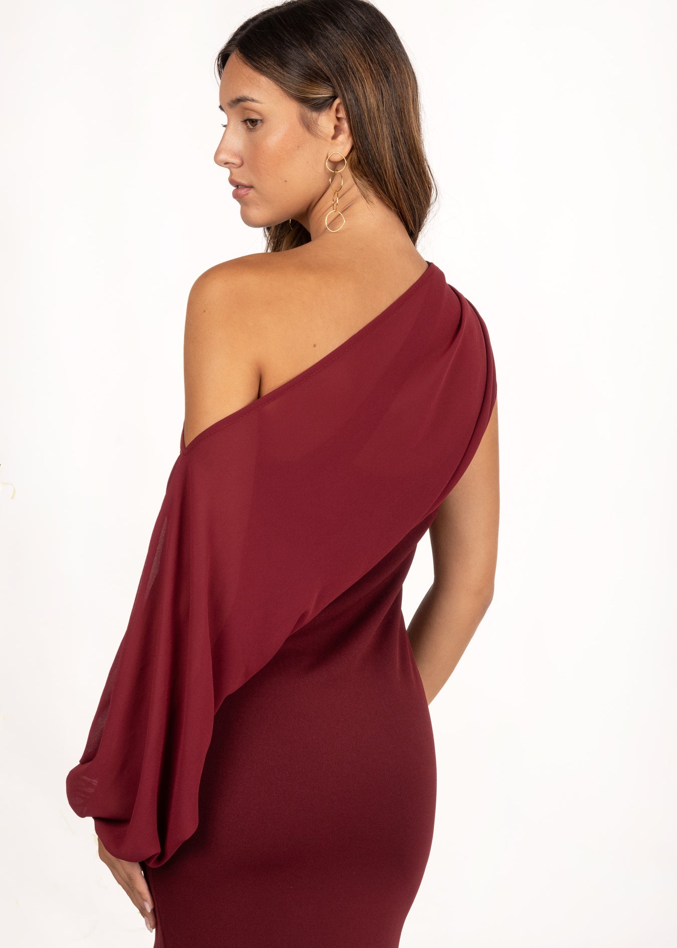 Vestido asimétrico color granate con manga extraíble, perfecto para un look de invitada de otoño. Su diseño versátil ofrece dos estilos: uno sofisticado con manga fluida, y otro más minimalista y elegante sin ella. La falda con godete aporta movimiento, ideal para bodas, galas y eventos especiales.