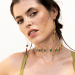 Choker Deriva Verde, collar dorado con piedras verdes, sobre vestido verde oliva