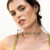 Choker Deriva Verde, collar dorado con piedras verdes, sobre vestido verde oliva