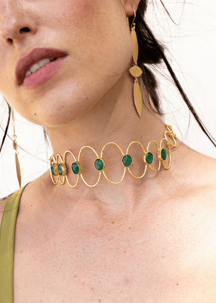 Detalle del choker Deriva Verde combinado con pendientes dorados a juego