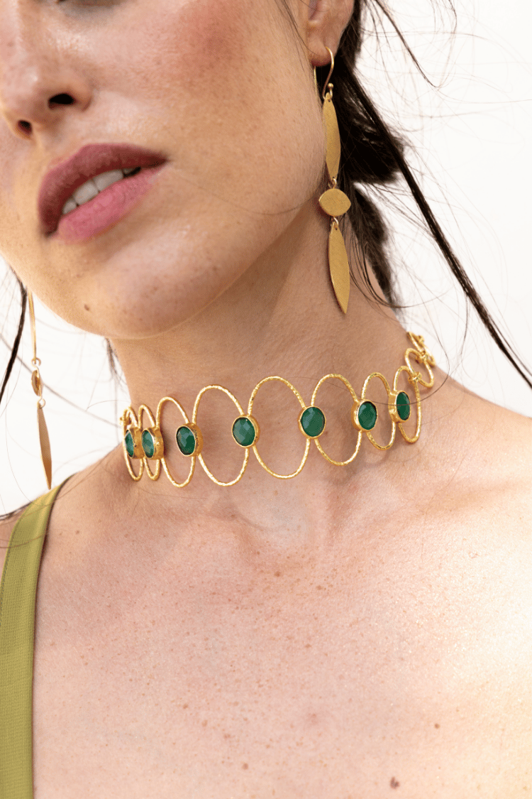 Detalle del choker Deriva Verde combinado con pendientes dorados a juego