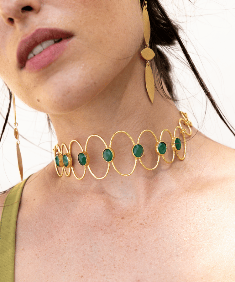 Detalle del choker Deriva Verde combinado con pendientes dorados a juego