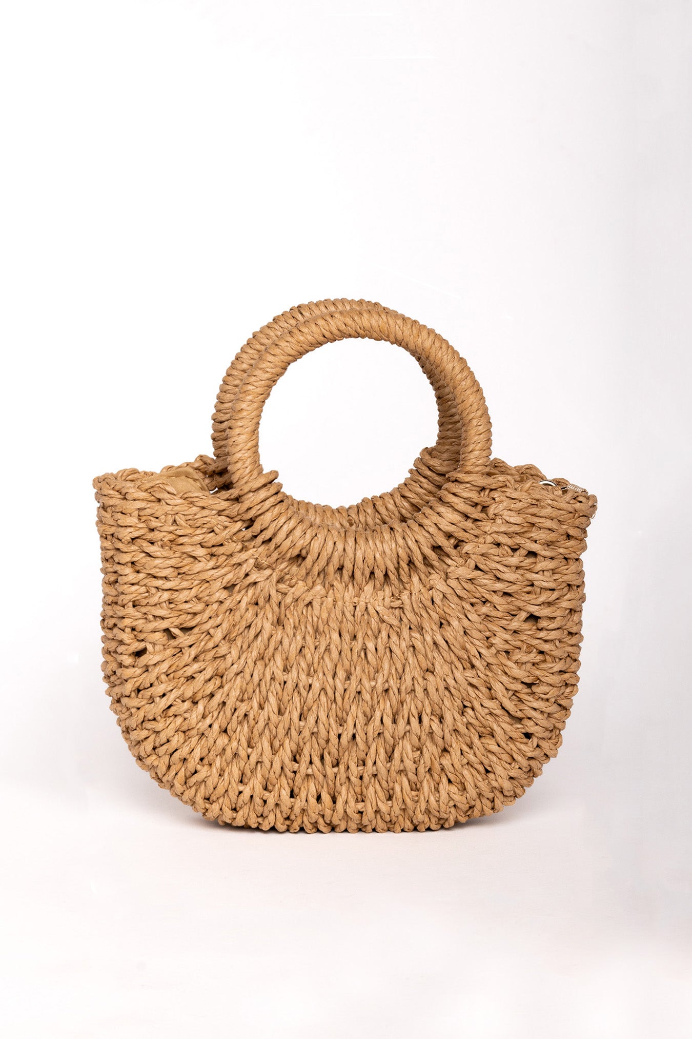 Bolso de rafia trenzada color camel con asas redondas rígidas y forma semiluna.