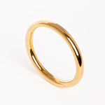 Brazalete dorado de diseño minimalista fotografiado en vista superior sobre fondo blanco