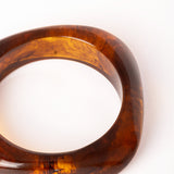  “Brazalete Regina Ámbar fotografiado de perfil, mostrando su forma geométrica cuadrada y acabado brillante.”