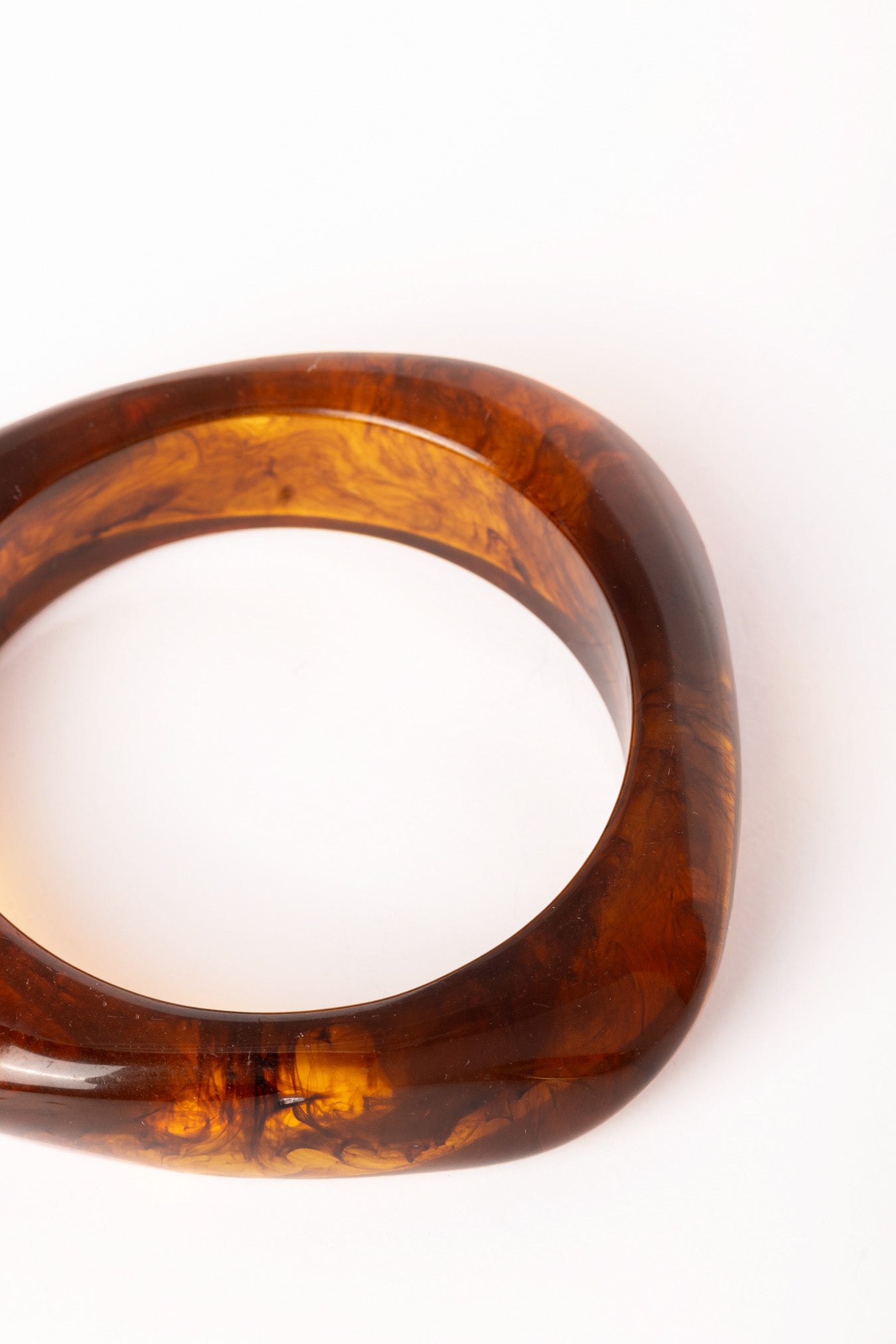  “Brazalete Regina Ámbar fotografiado de perfil, mostrando su forma geométrica cuadrada y acabado brillante.”