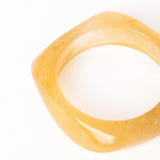 “Plano detalle del Brazalete Regina Beige, destacando su acabado brillante y diseño geométrico.”