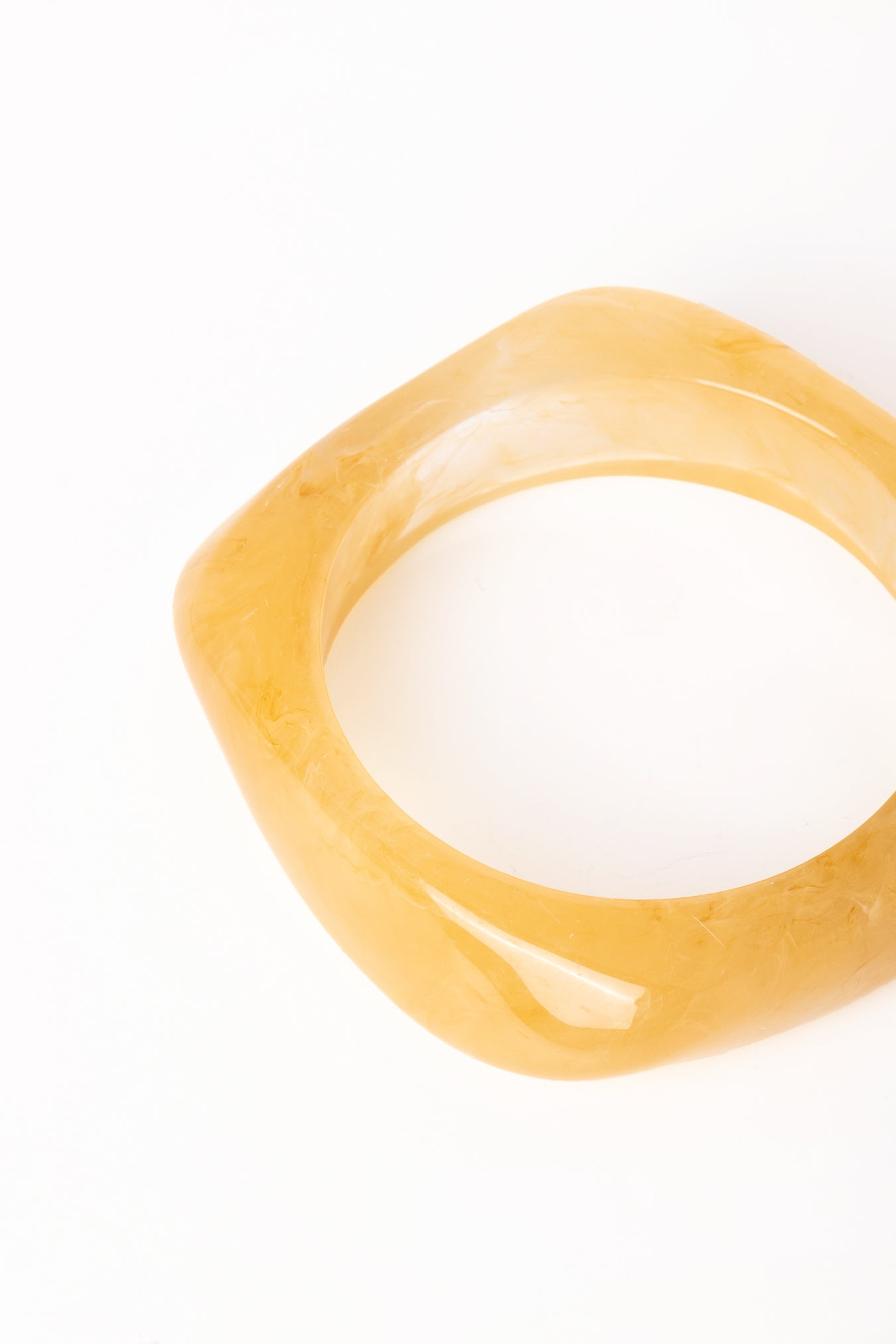 “Plano detalle del Brazalete Regina Beige, destacando su acabado brillante y diseño geométrico.”