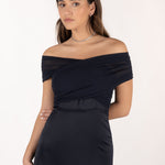 Vestido Eleonor azul noche en posición escote bardot, mostrando la versatilidad del diseño multiposición.