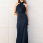 Modelo con vestido largo Eleonor azul noche con escote asimétrico y diseño elegante.