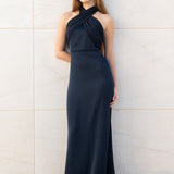 Modelo con vestido largo Eleonor azul noche con escote asimétrico y diseño elegante.