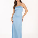 Vista frontal de modelo con vestido largo color celeste con fulares atrás. Escote palabra de honor.