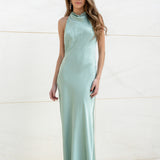 Vista frontal de modelo con vestido largo color menta de satén y escote halter.