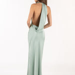 Vista posterior de modelo con vestido largo color menta de satén y espalda descubierta.