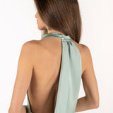 Detalle vista posterior de modelo con vestido color menta y espalda descubierta.