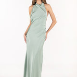 Vista frontal de modelo con vestido largo color menta de satén y escote halter.