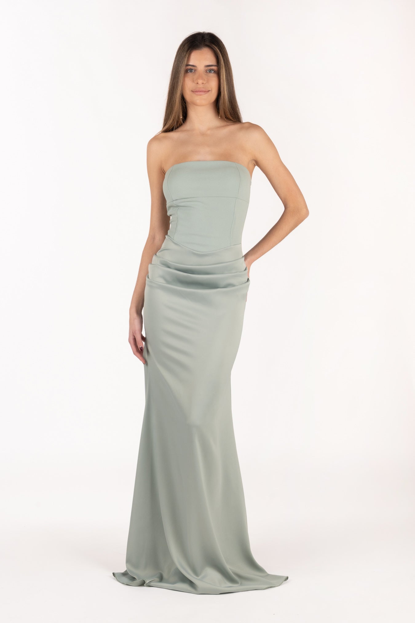 Modelo con vestido largo Isabella color salvia con escote palabra de honor y diseño elegante.