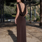 Invitada con vestido marrón chocolate de espalda descubierta y drapeado fluido, ideal para eventos de día elegantes.