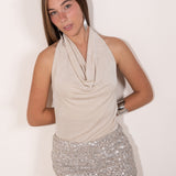 Top beige con escote cascada y espalda descubierta.  