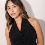 Modelo con Top negro con escote drapeado tipo halter, estilo elegante y femenino