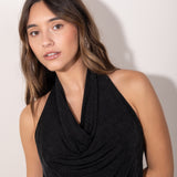 Modelo con Top negro con escote drapeado tipo halter, estilo elegante y femenino