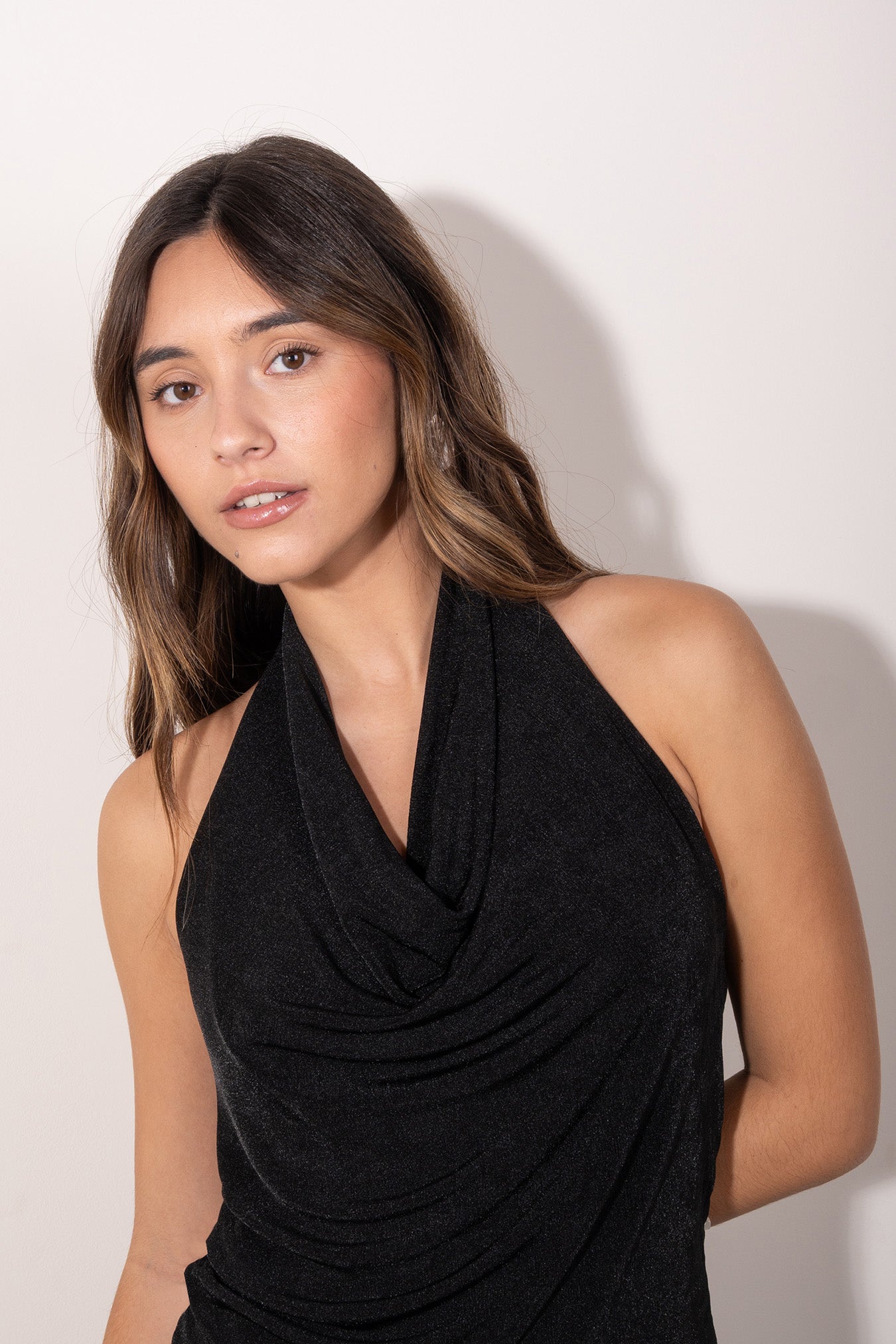 Modelo con Top negro con escote drapeado tipo halter, estilo elegante y femenino