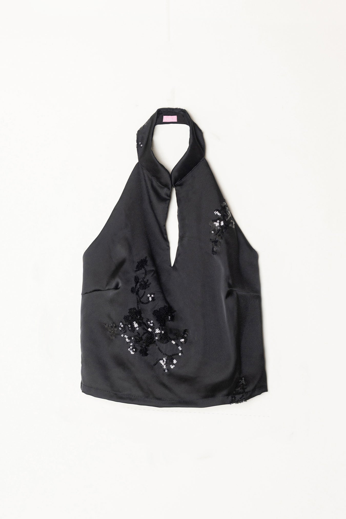 Top negro halter con abertura central y detalles de lentejuelas florales en la parte frontal