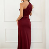 modelo con vestido largo granate de fiesta perfecto para eventos especiales, bodas, galas o cenas formales. Diseño asimétrico de un solo hombro. La silueta entallada resalta la figura, mientras que la sutil franja de encaje floral en la cintura añade un toque romántico y sensual, sin perder la clase.
Detalle: Encaje semitransparente en la cintura