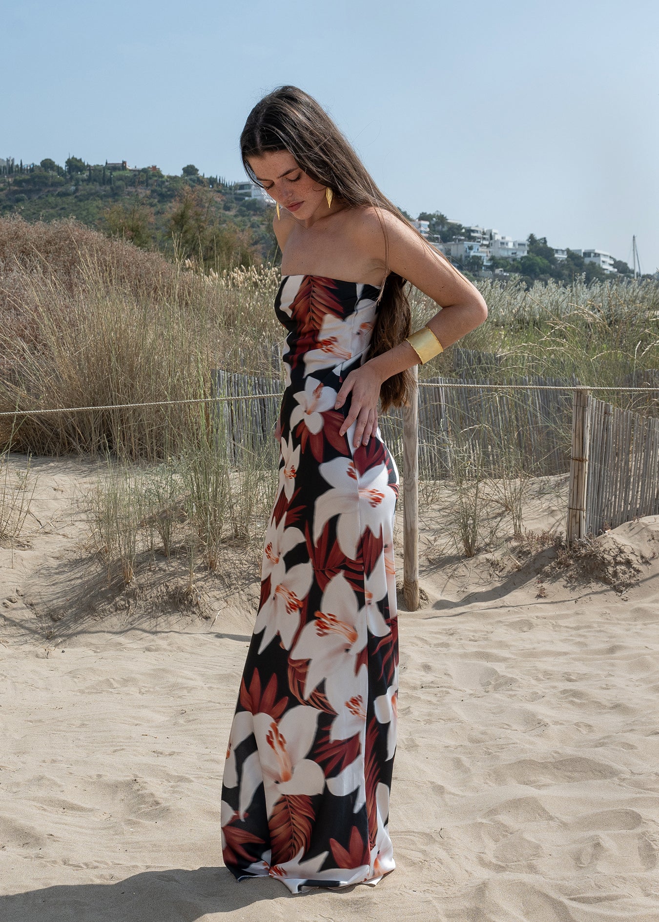Vista lateral vestido largo palabra de honor con estampado floral en la playa