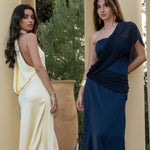 Isabella con el vestido multiposición Timeless azul noche, configurado con la tira larga sobre el hombro a modo de capa fluida para un look de invitada de día.