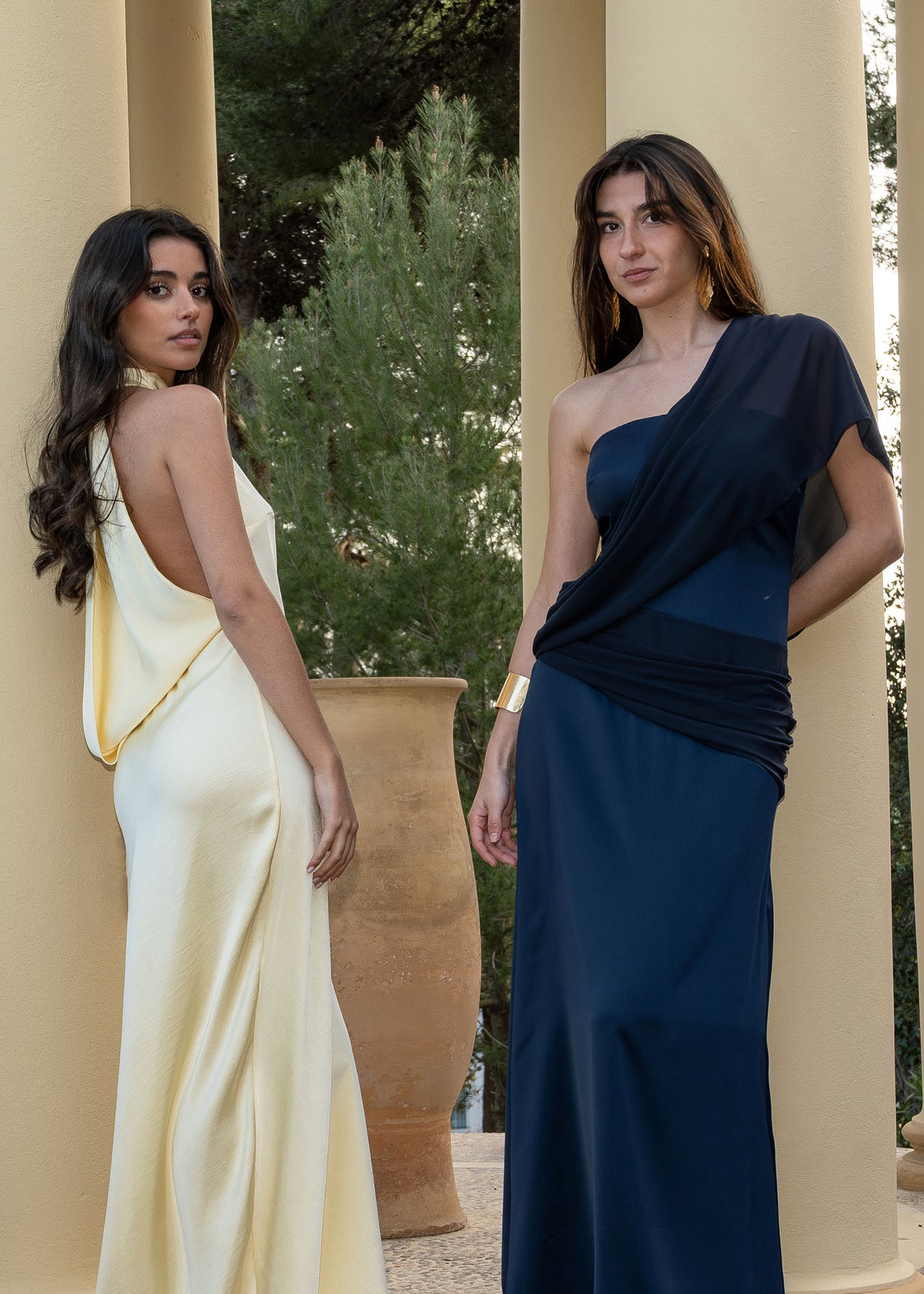 Isabella con el vestido multiposición Timeless azul noche, configurado con la tira larga sobre el hombro a modo de capa fluida para un look de invitada de día.