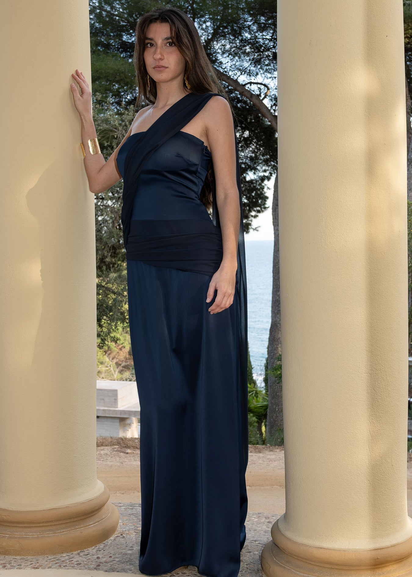 Isabella con el vestido Timeless azul noche en versión asimétrica, destacando la tira larga cayendo como una capa elegante.