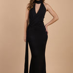 Vestido negro largo de invitada con espalda descubierta, cuello halter y abertura lateral, ideal para eventos elegantes - Closet.bcn