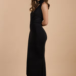 Vestido negro largo de invitada con espalda descubierta, cuello halter y abertura lateral, ideal para eventos elegantes - Closet.bcn