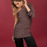 Modelo posando con Vestido asimétrico corto en color cobre brillante. Combinado con pantalones satinados negros.