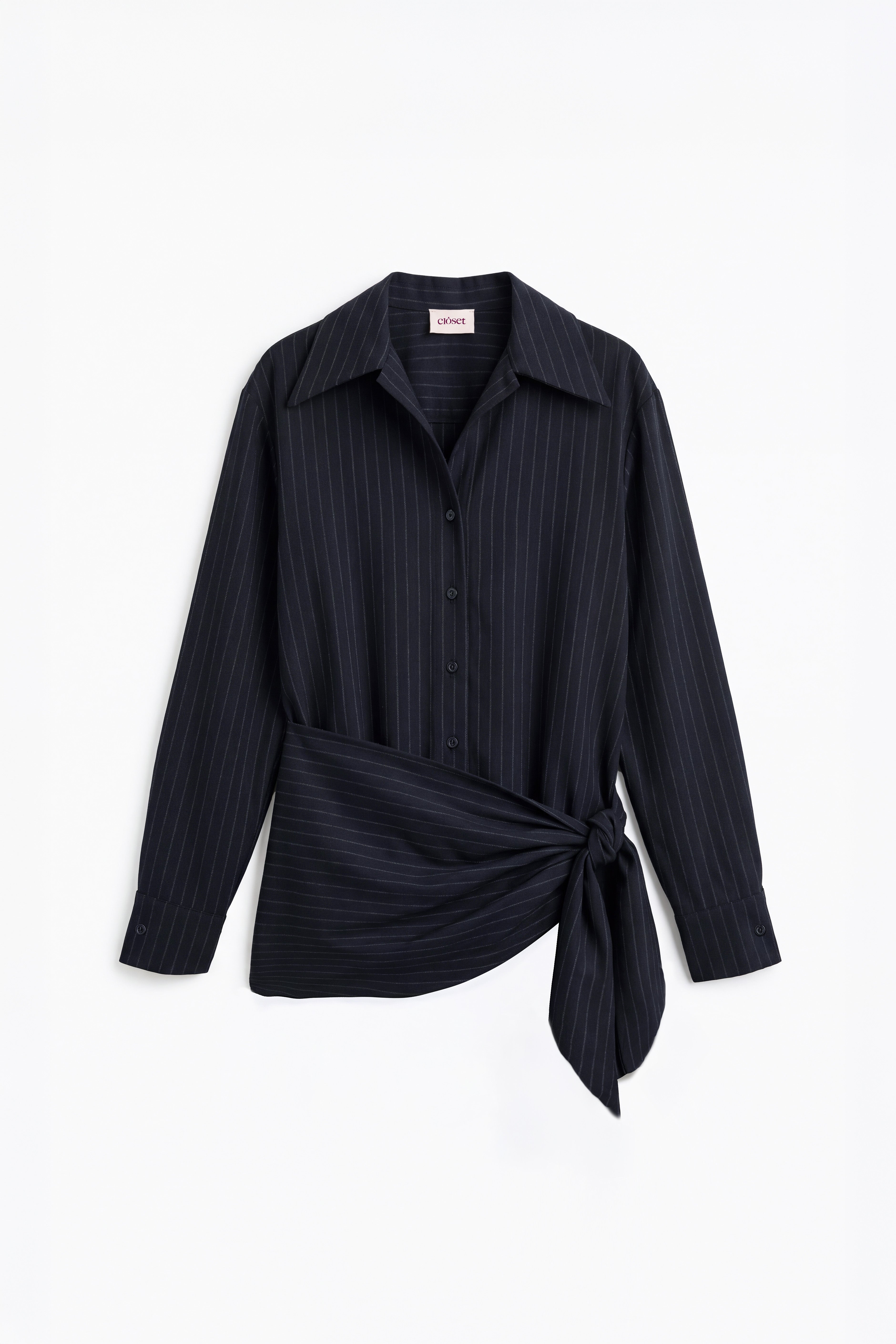 Camisa azul marino con raya diplomática y nudo en la cintura para mujer, mostrada de frente sobre fondo blanco neutro.