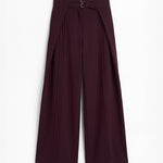 Pantalón berenjena de corte holgado con pliegues y doble hebilla para mujer, mostrado de frente sobre fondo blanco neutro.