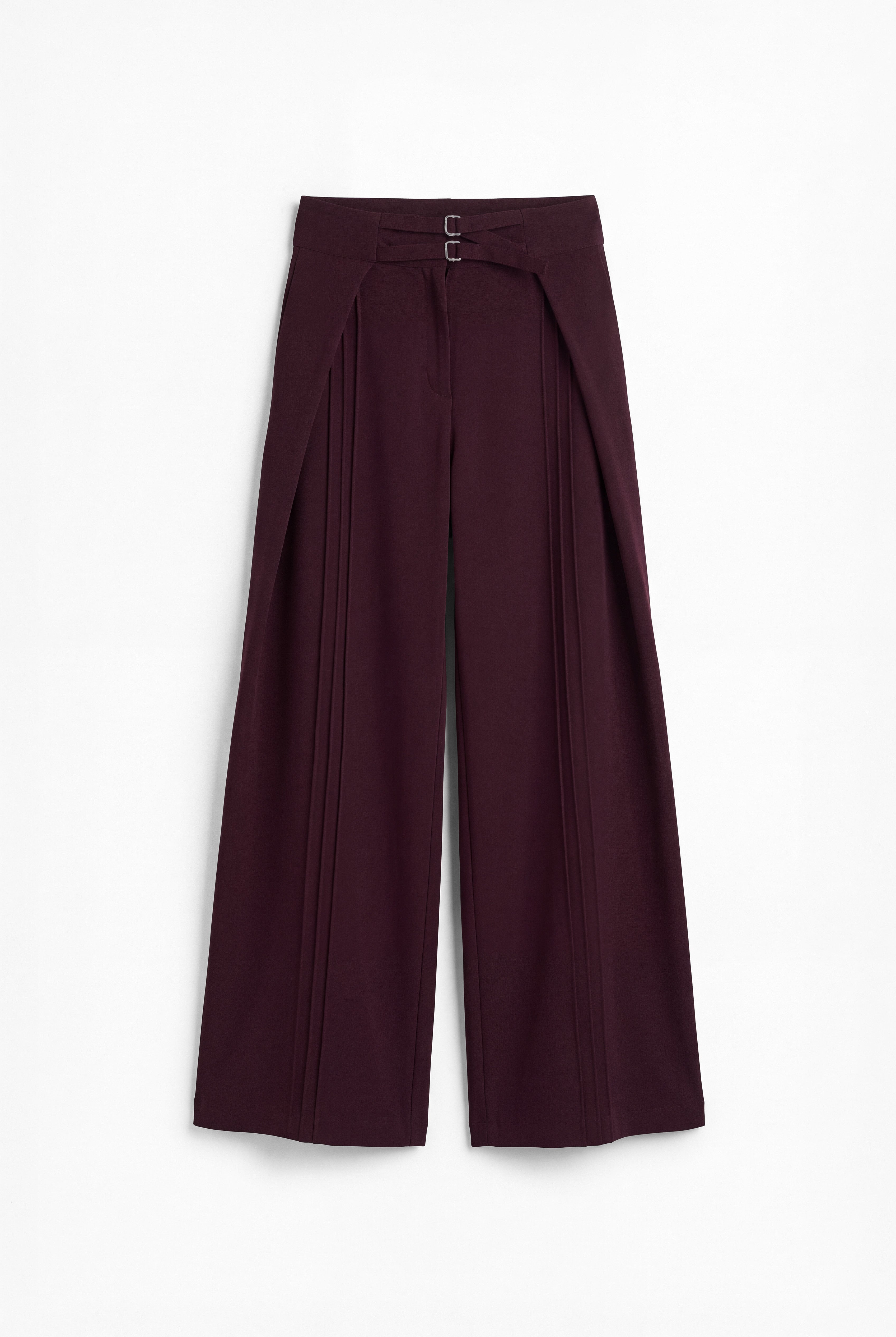 Pantalón berenjena de corte holgado con pliegues y doble hebilla para mujer, mostrado de frente sobre fondo blanco neutro.