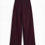 Pantalón berenjena de corte holgado con pliegues y doble hebilla para mujer, mostrado de espaldas sobre fondo blanco neutro.