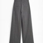 Pantalón gris de corte holgado con pliegues delanteros y doble hebilla para mujer, mostrando la vista trasera sobre fondo blanco neutro.