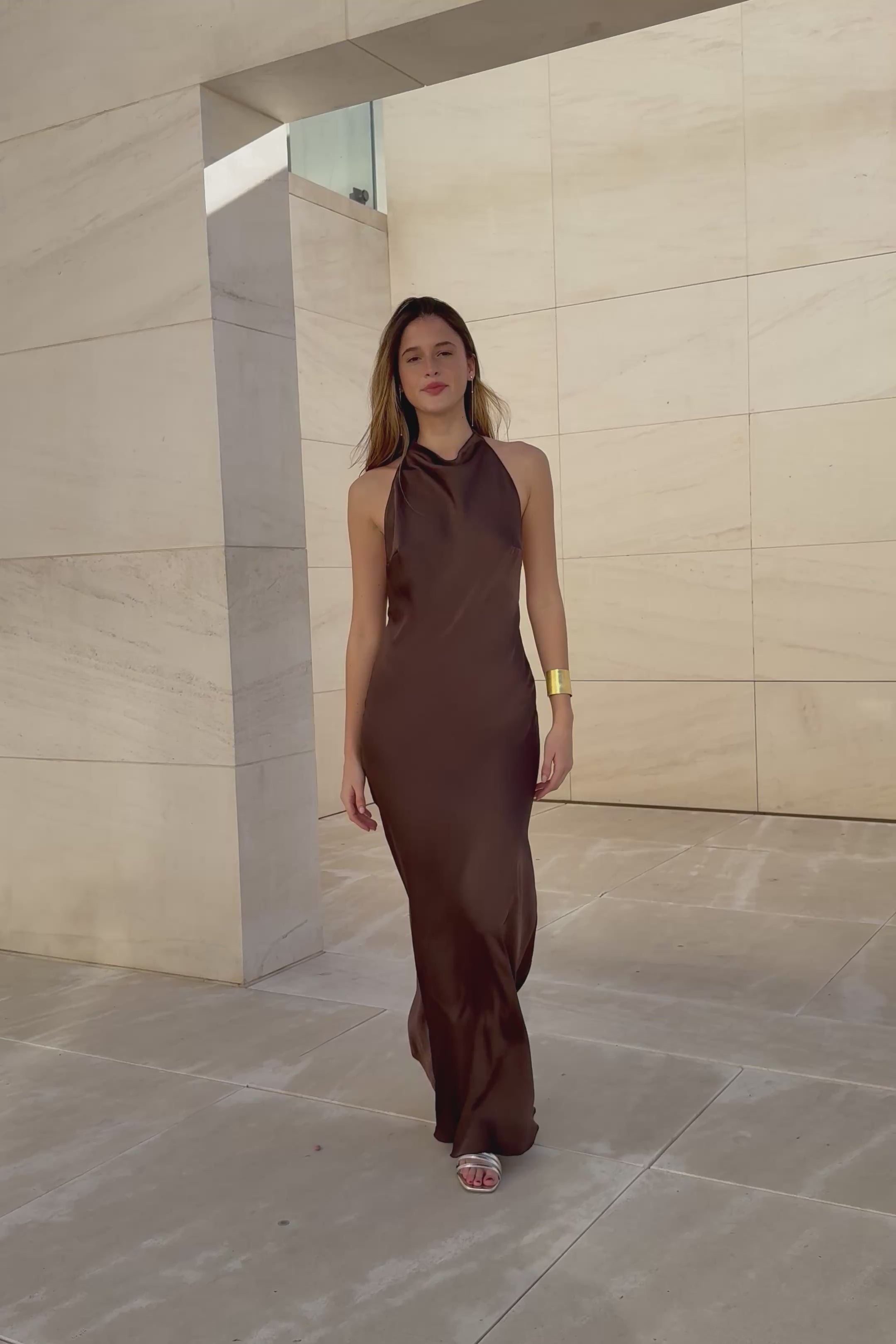 Modelo con vestido largo marrón Icon, vista completa mostrando la silueta elegante.